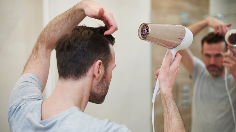 man blow drying hair