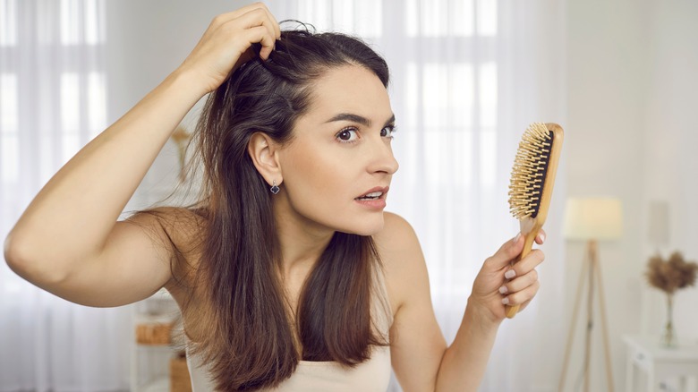 Woman with thinning hair holding brush