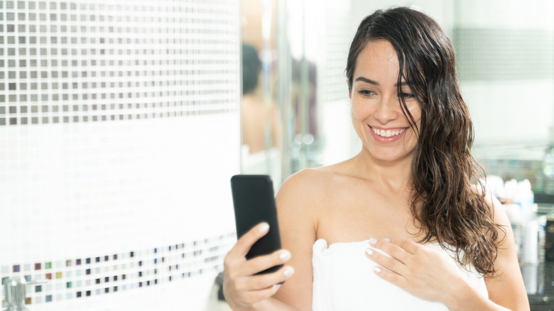 woman using smartphone after showering