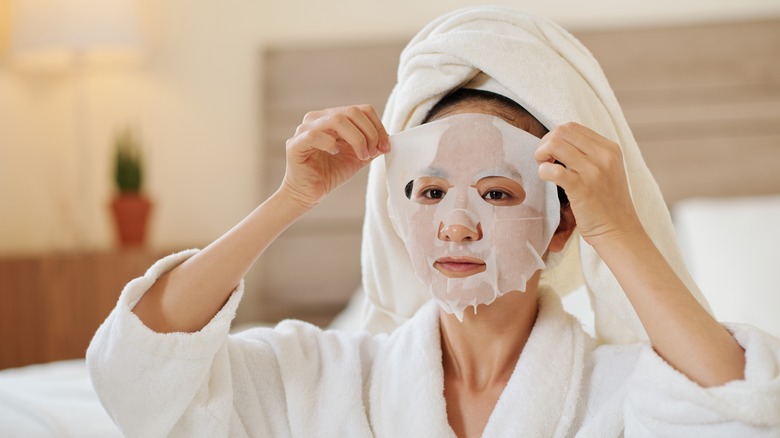 Woman removing sheet mask from face