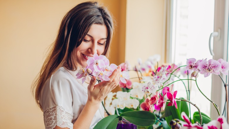 Woman smiling, smelling flowers