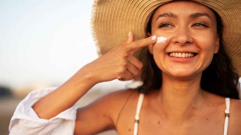 smiling girl applying sunscreen