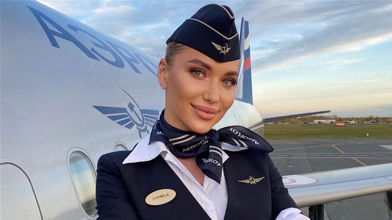 air hostess standing near plane