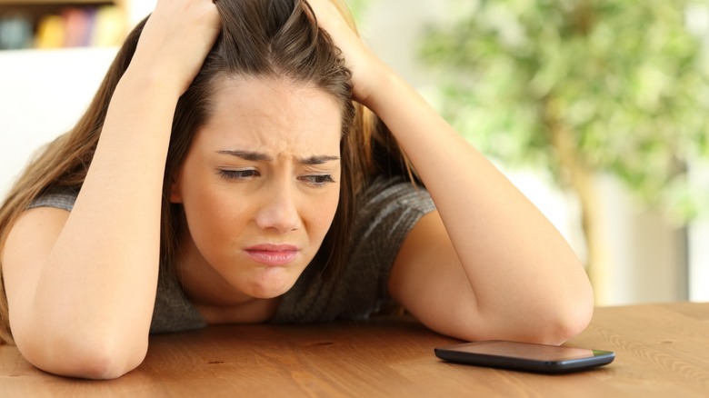Stressed woman looking at phone