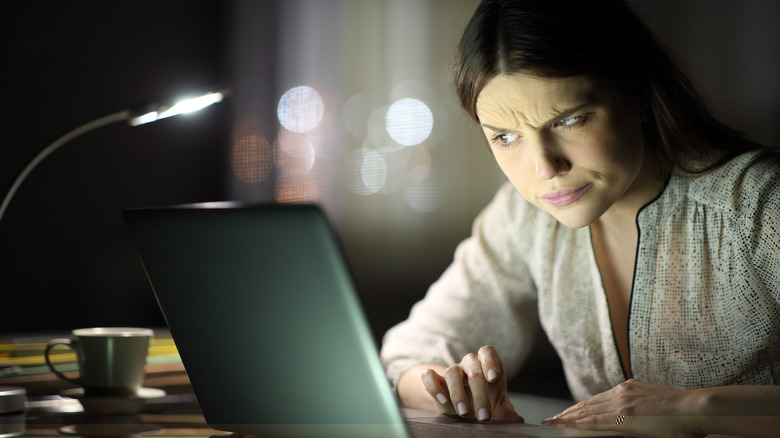 Woman suspiciously eyes laptop