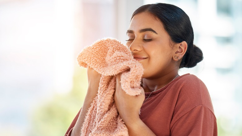 Happy woman smelling a towel