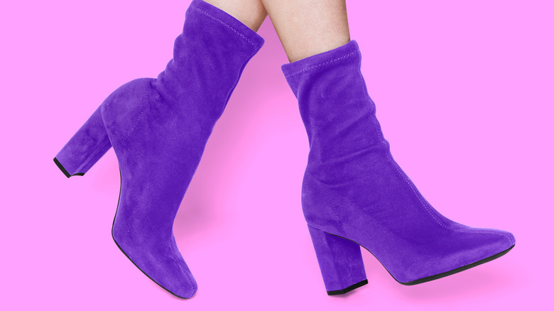 Purple ankle boots on pink background