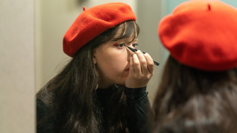 Woman applies eyeliner 