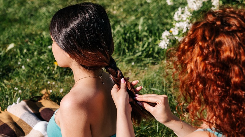 A woman doing a braid on her friend