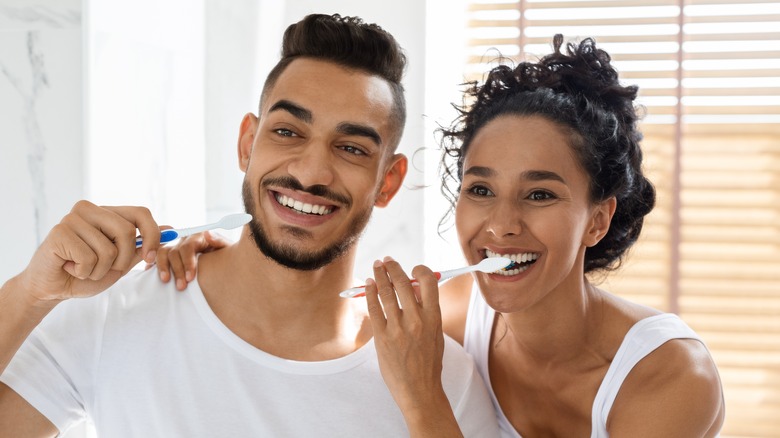 happy couple brushing teeth