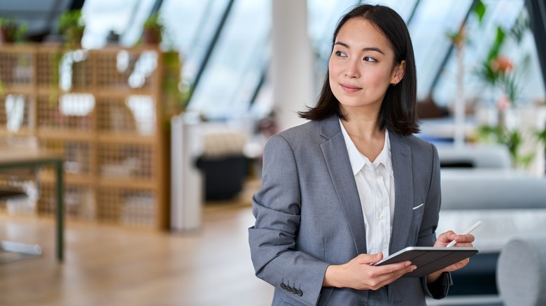 asian businesswoman holding ipad in office